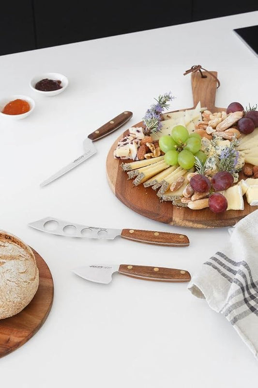 Arcos Cheese Knife set 3 pieces. Nitrum Stainless Steel. Very useful set for irregular pieces of hard cheeses, soft cheeses and creamy cheeses. Handle 100% Ovengkol wood Series Nordika. Color Brown.