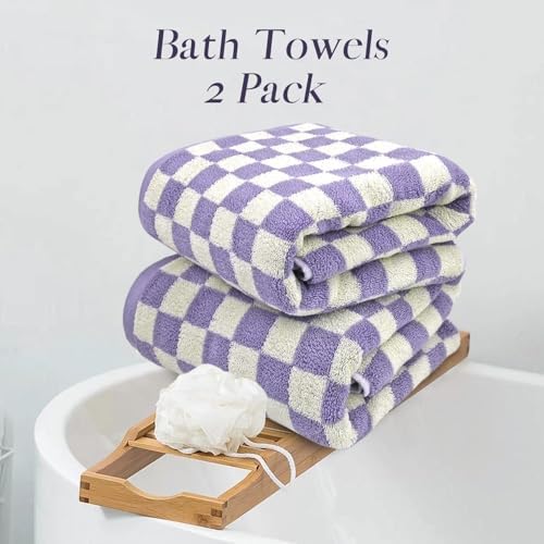 Two folded purple and cream checkered bath towels stacked on a wooden tray next to a white bathtub, with the text 'Bath Towels 2 Pack' at the top.