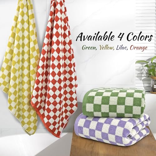 Four checkered towels in green, yellow, red, and purple on a wooden surface with a white wall background.