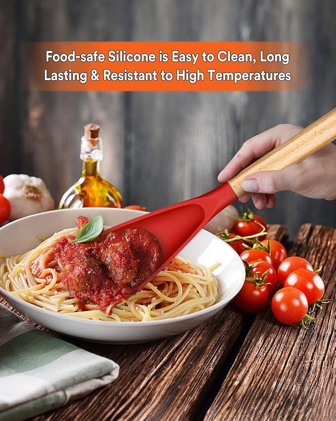 Red silicone spatula being used to serve spaghetti with meatballs on a wooden table.