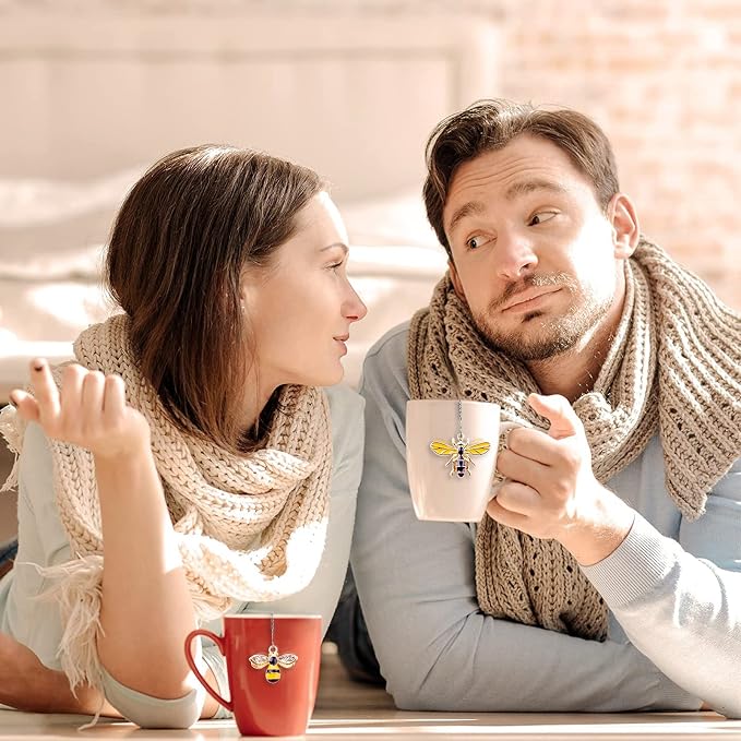 Two people sitting together, one holding a mug with a moon design, against a blurred indoor background.