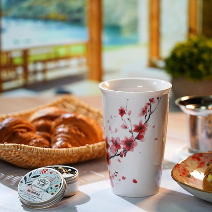 White mug with floral design on a table with pastries and a scenic background